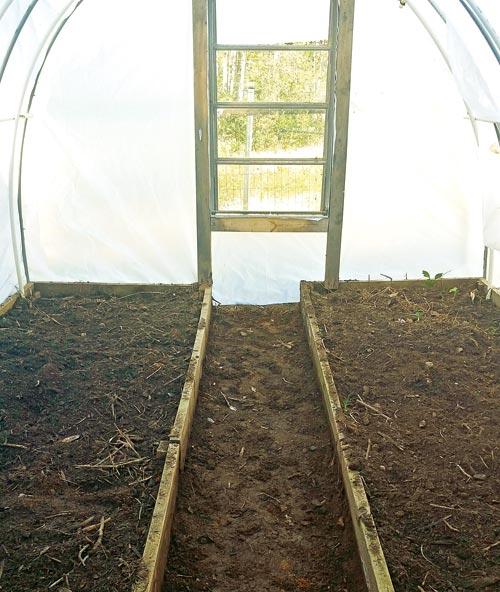 The inside of the greenhouse has a two-foot-wide walkway through the middle. There are windows on each end to make it easy to ventilate.