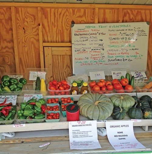 Roadside stand fully stocked with fresh produce.