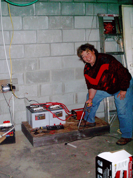Our new battery bank, inverter; old 12 volt water pump on wall to left, next to storage tank