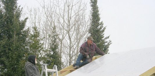 Despite rain and snow, the greenhouse gets built