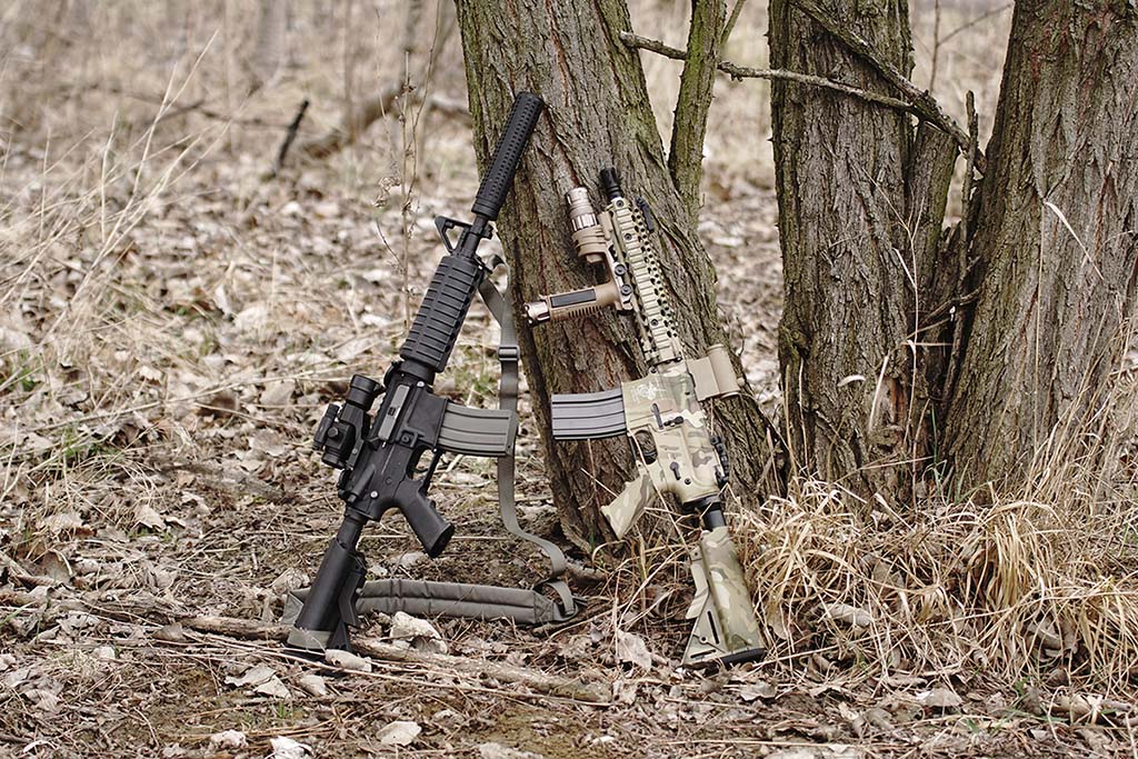 Two AR-15 rifles standing on a tree