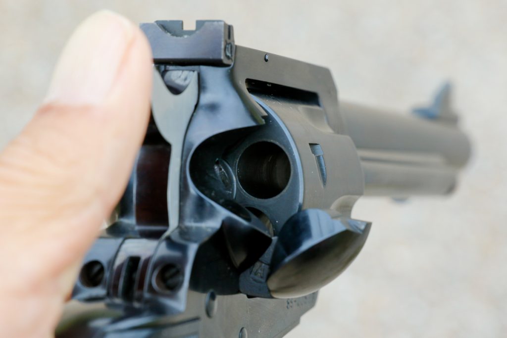 Loaded/unloaded status on this type of revolver is normally checked by opening loading gate as shown, rotating cylinder, and checking chamber by chamber. If rules on set do not allow actor to do this, actor has other ways of checking load status, as discussed in text and other captioned photos.