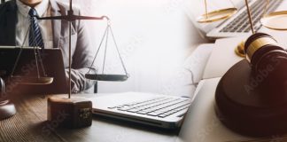 Justice and law concept. Gavel on sounding block in hand's Male judge at a courtroom, working with document law books, report the case on table in modern office.