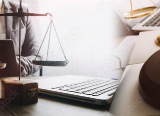 Justice and law concept. Gavel on sounding block in hand's Male judge at a courtroom, working with document law books, report the case on table in modern office.